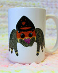 Hand-drawn cartoon orange-and-black regal jumping spider on a ceramic mug.