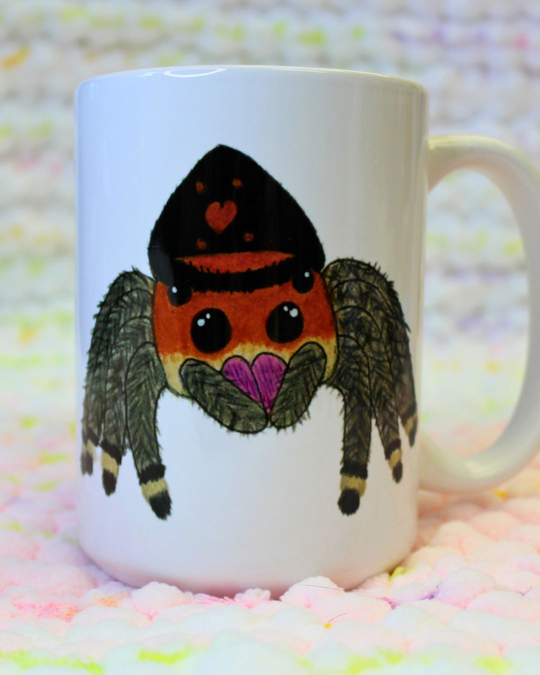 Hand-drawn cartoon orange-and-black regal jumping spider on a ceramic mug.