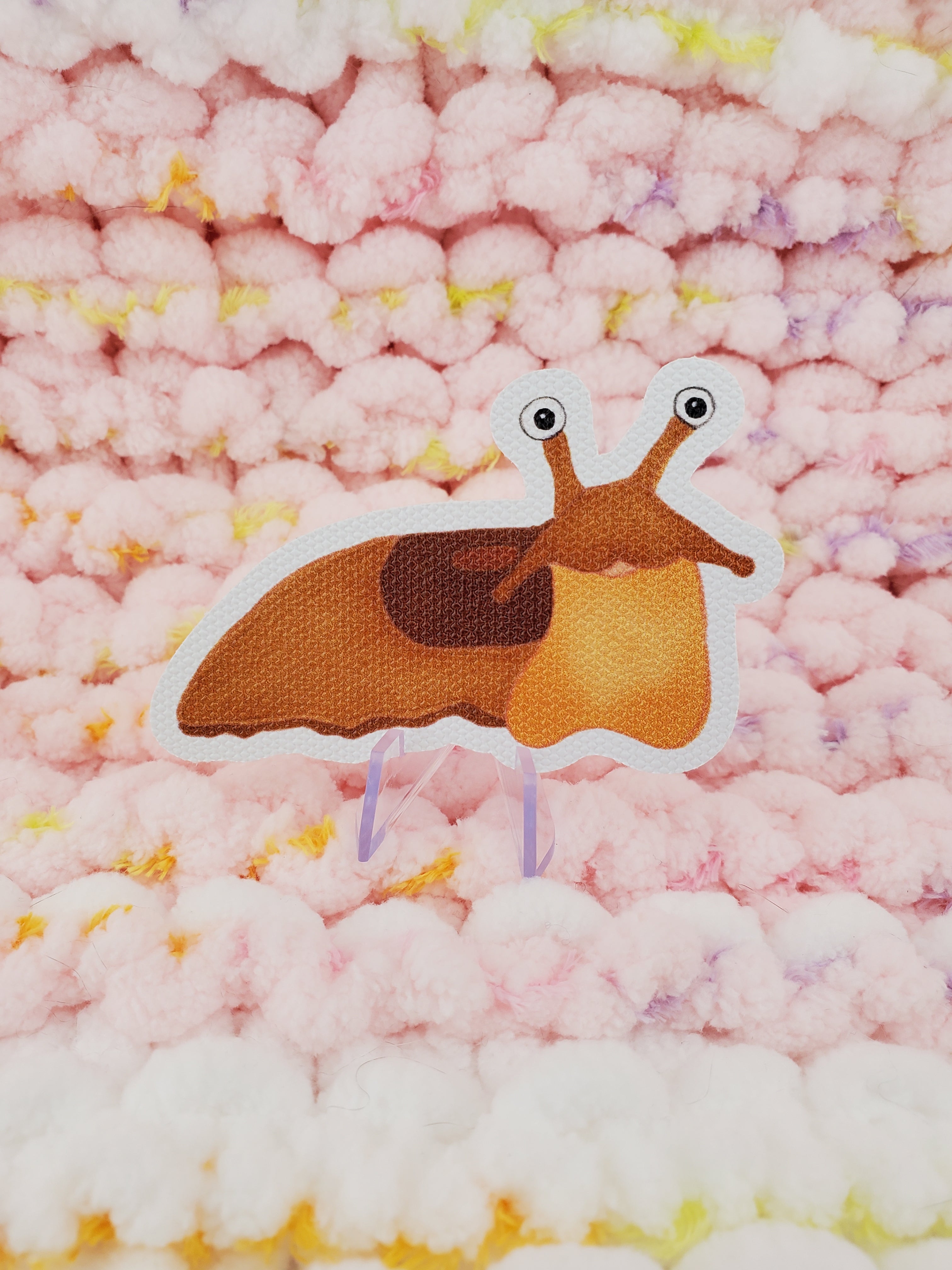3inch textured sticker of a cartoon-style happy light brown slug.